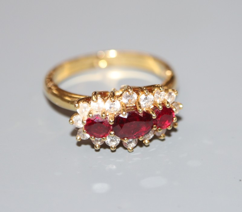 A modern yellow metal, ruby and diamond set triple cluster ring, with expanding shank, size 0-R, gross weight 5 grams.